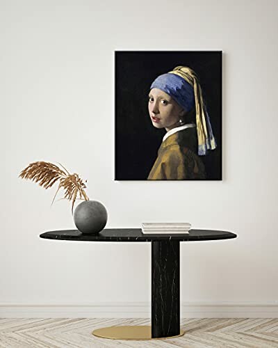 Table with vase and painting of a woman on the wall.
